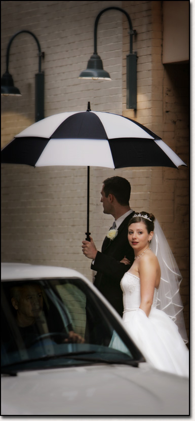 bride and groom crossing street in rain